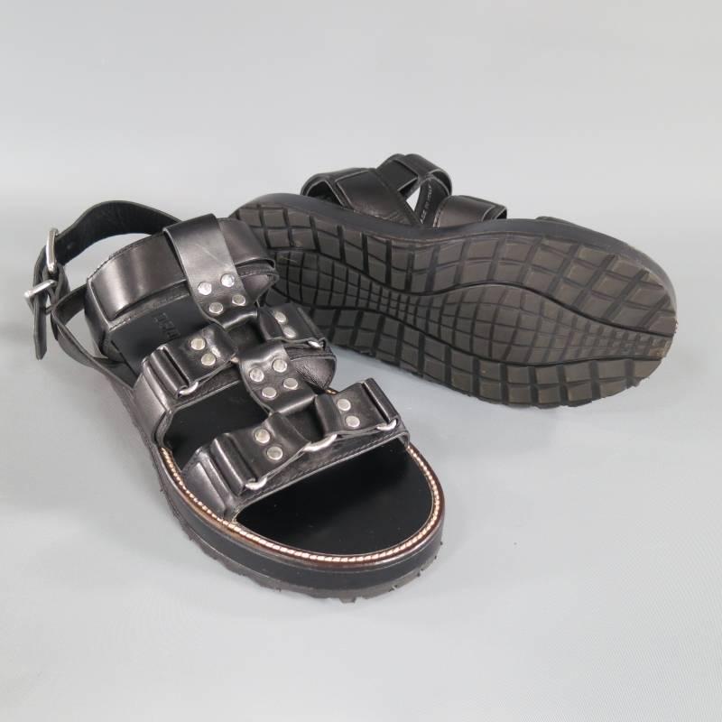 Diese einzigartigen Laufsteg-Sandalen von DSQUARED2 sind aus schwarzem Leder gefertigt und verfügen über eine Gladiatorenkonstruktion aus Leder:: die von Fetisch-Geschirren inspiriert ist:: mit silberfarbenen O-Ringen und Nieten:: einem