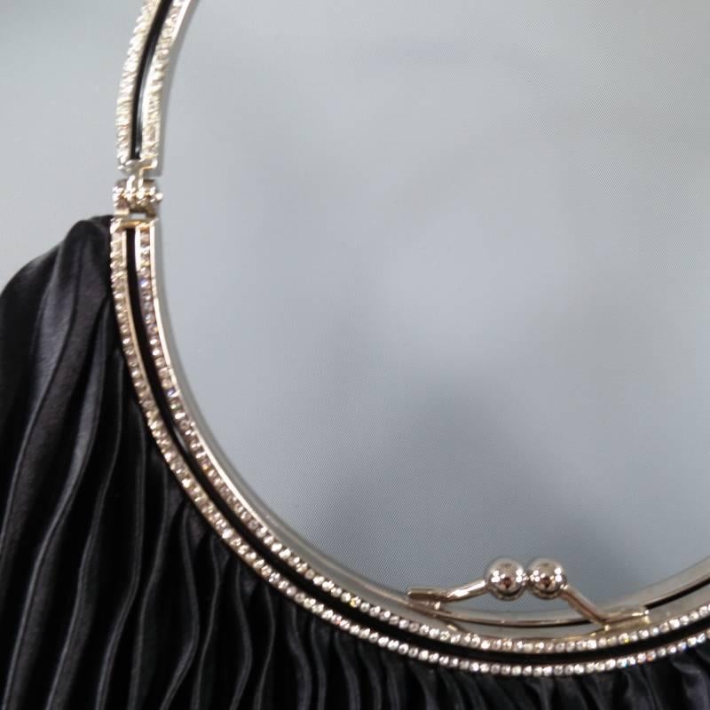 This gorgeous evening handbag by VALENTINO GARAVANI comes in a black pleated silk satin and features a small rounded silhouette, kiss lock, circular silver tone crystal embellished handle with black enamel stripe and mauve pink lining. Made in