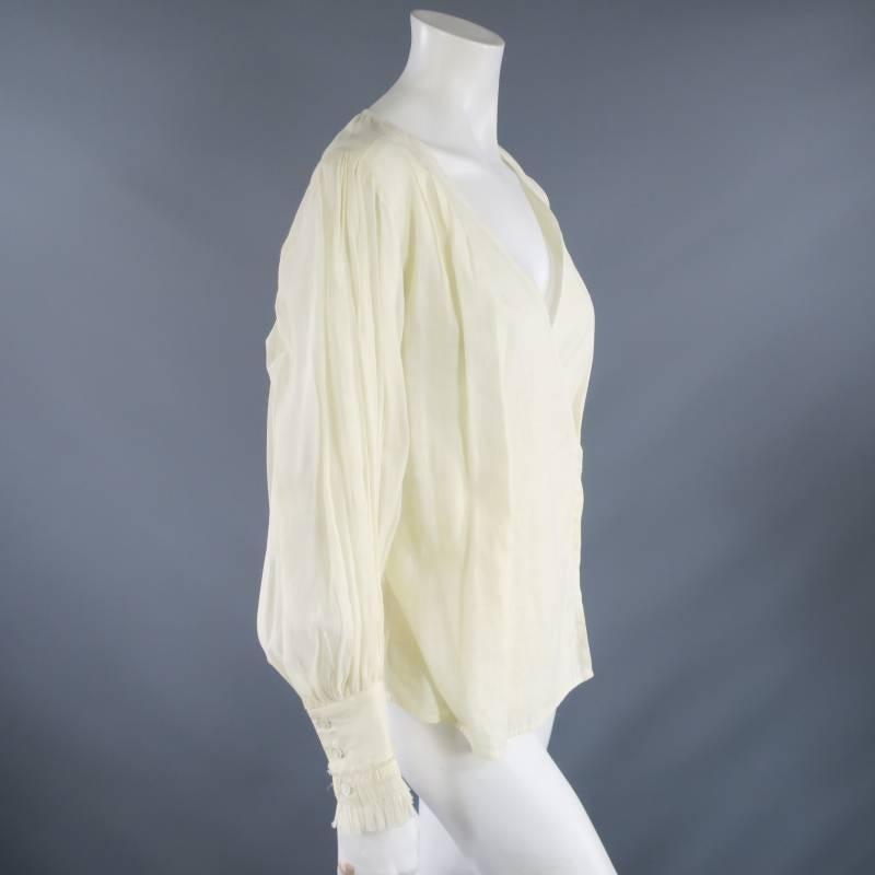 The gorgeous OSCAR DE LA RENTA blouse comes in a semi sheer light beige cotton and features a V neck wrap closure, shoulder pleat details, and pleated tapered puff sleeves with ruffled hem. Spring/Summer 2011. Made in The USA.
 
Excellent