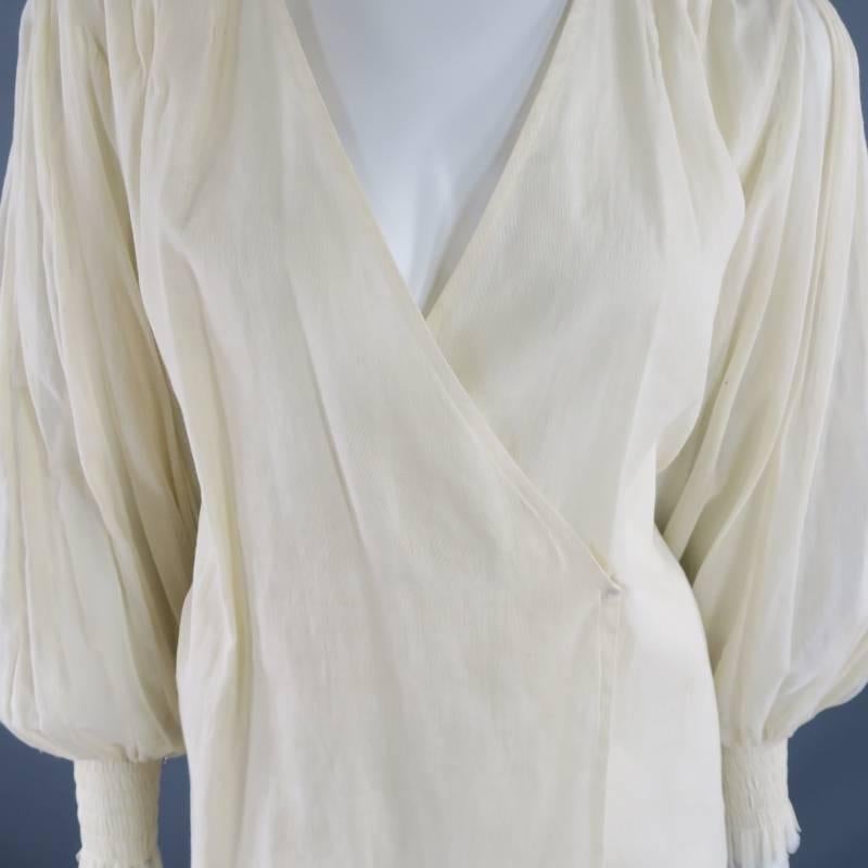 This lovely OSCAR DE LA RENTA blouse comes in a light beige, semi sheer linen and features a V neck with wrap closure, gold sequin embellished shoulder panels, and pleated bishop sleeves with stretch wrist cuffs. Spring 2010. Made in The USA.
