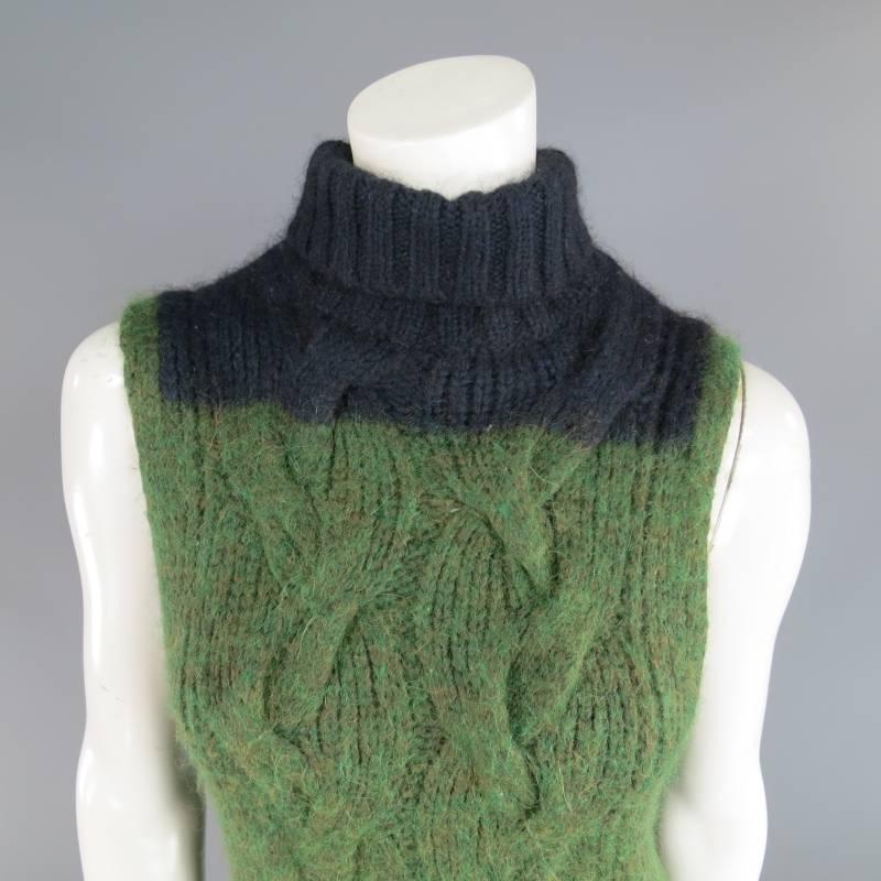 This fabulous DRIES VAN NOTEN sleeveless sweater comes in a blended textured green cable knit and features a navy blue color block top with turtle neck. Perfect layering piece for chilly weather. Made in Belgium.
 
Excellent Pre-Owned