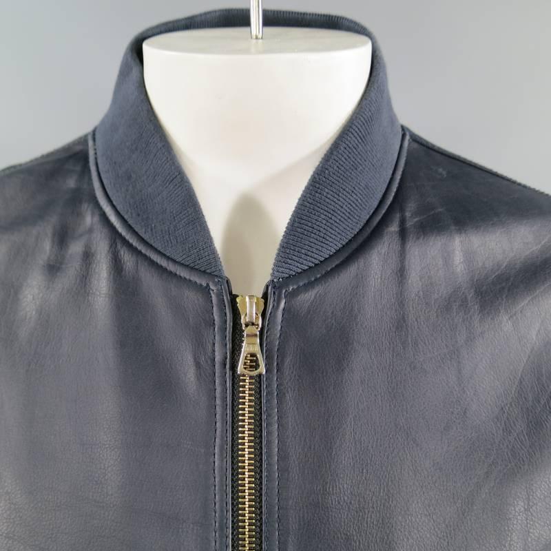 This classic MA-1 inspired bomber jacket by PS PAUL SMITH comes in a smooth soft navy leather and features a gold double zip closure, double slit pockets with snap closure, classic bomber sleeve pocket, Hawaiian print satin lining. Retails: