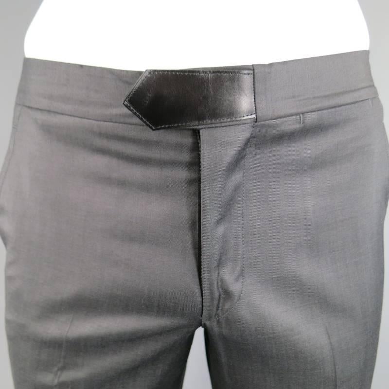 HERMES Dress Pants consists of wool material in a black color tone. Designed with a zip-fly closure, quarter side pockets and leather trim belt tab on waist. Straight relaxed leg with a sheen appearance. Back includes 2 inseam pockets with button