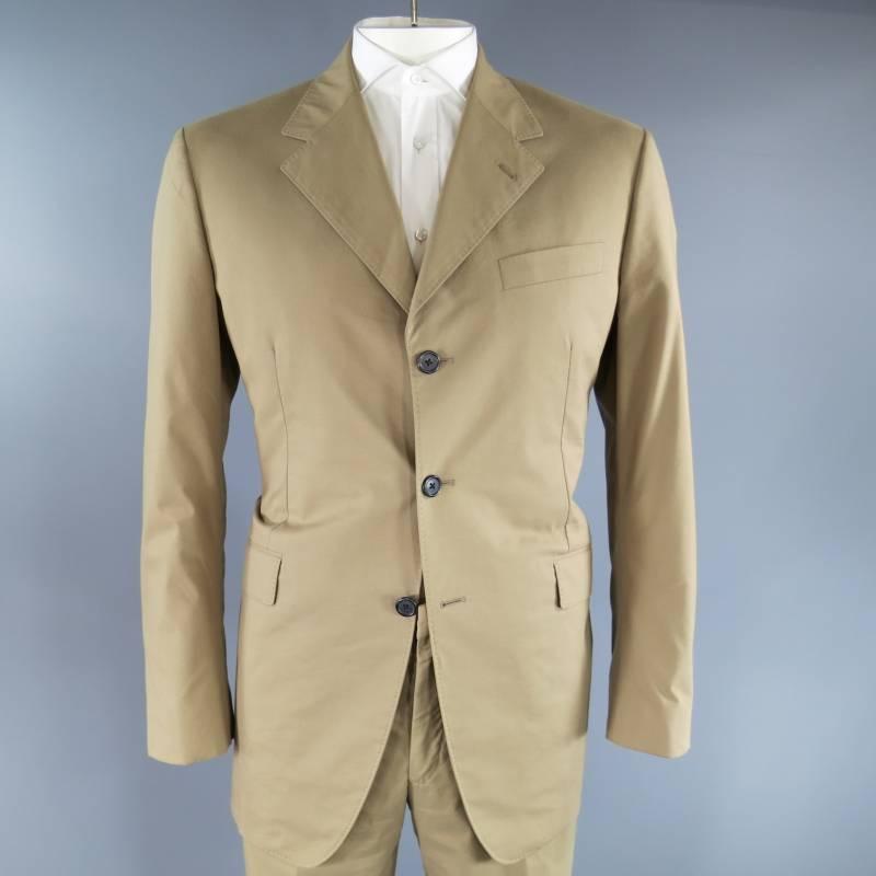 PRADA's blended cotton suit features three button closure, three jetted pockets with atelier stitch detail along front panel, dart detail at waist. The trousers feature flat hook & eye closure with zip fly, contemporary quarter pockets, jetted