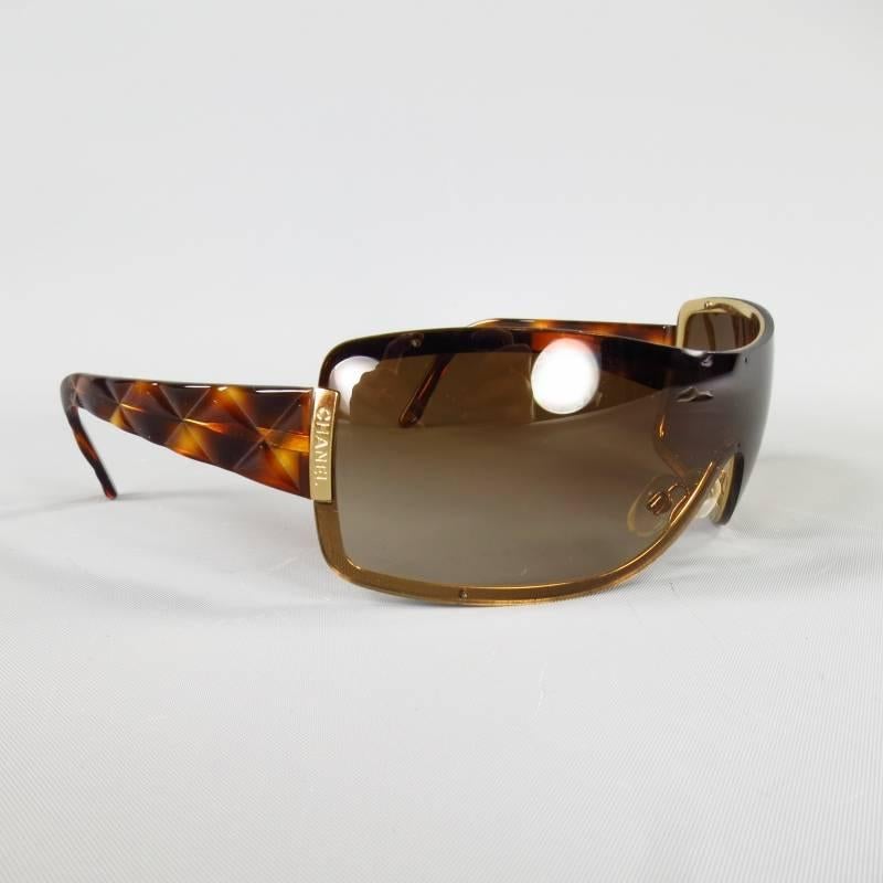 These CHANEL sunglasses feature a brown gradient lens with gold tone frame, Engraved logo sides, and thick, quilted textured tortoise arms. With case. Made in Italy.
 
Good Pre-Owned Condition.
 
Front: 7 in. X 2 in.
Arm: 4.25 in.

Item ID: