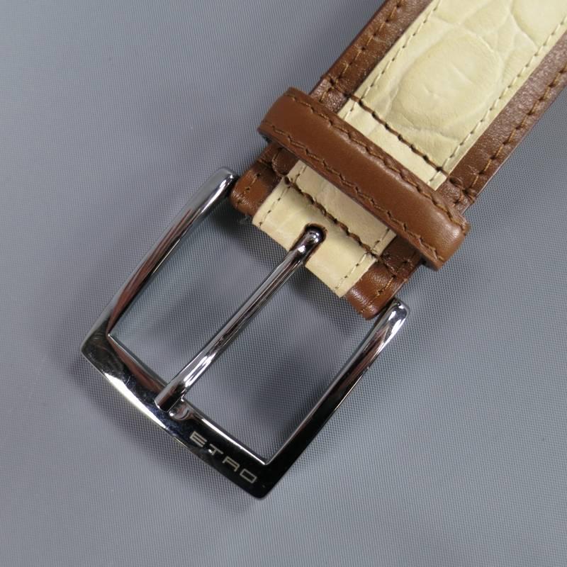 ETRO Belt consists of a beige two-tone leather material that features embossed texture. Designed with a two-tone appearance in brown and beige, tone-on-tone stitching can be seen towards mid-section, including brown loop with a silver buckle. Made