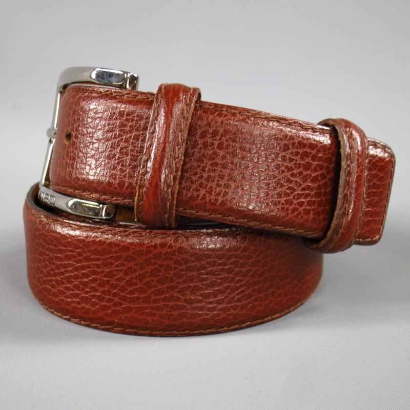 This classic ETRO dress belt features a rich reddish brown textured leather buckle with wop stitching and a silver tone rectangular engraved buckle.Made in Italy.
 
Excellent Pre-Owned Condition.     Marked: 85
 
Measurements:
 
Length: 41