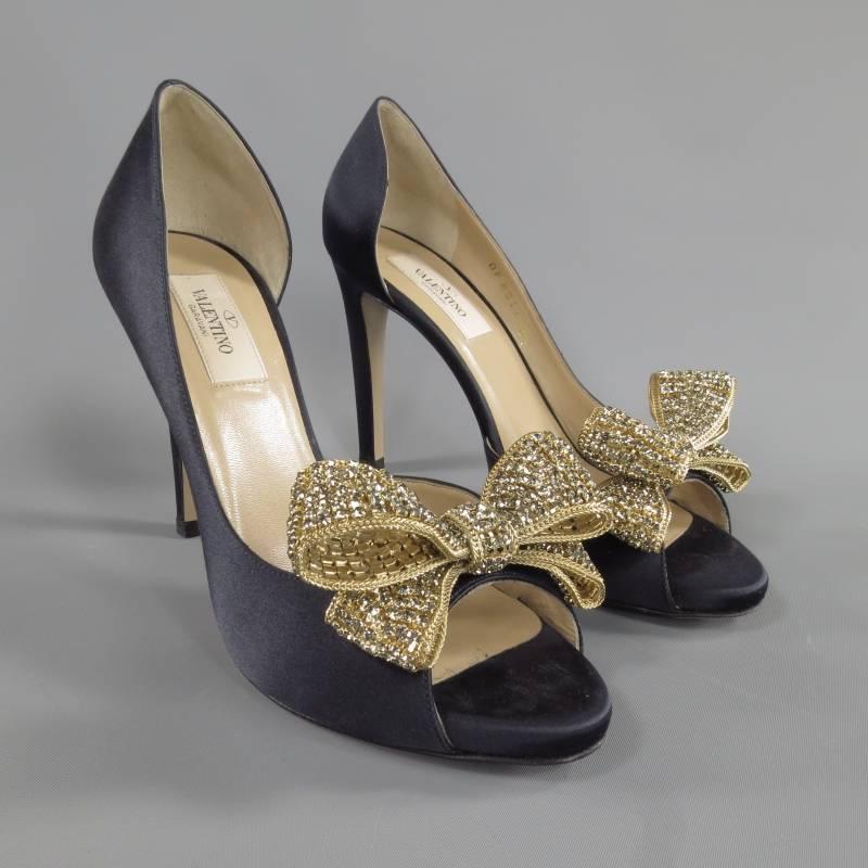 These stunning VALENTINO half D'orsay pumps come in a Midnight navy silk satin and feature a peep toe, concealed platform, and gorgeous, sparkling, gold tone metal, rhinestone bows. Made in Italy.
 
Excellent Pre-Owned Condition.     Marked: