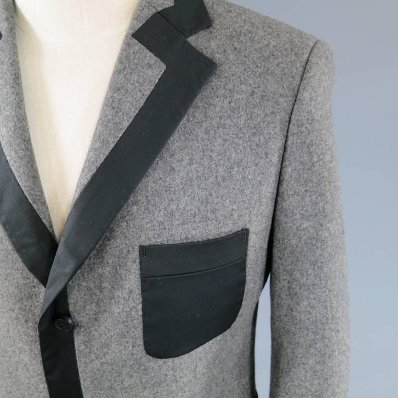FIFTH AVENUE SHOE REPAIR wool sports coat is tuxedo inspired and features elegant black trim throughout, tri-button closures, 3 patch pockets and dart detailing in neutral gray.
 
Excellent Pre-Owned Condition    Marked: 46
 
Measurements:
