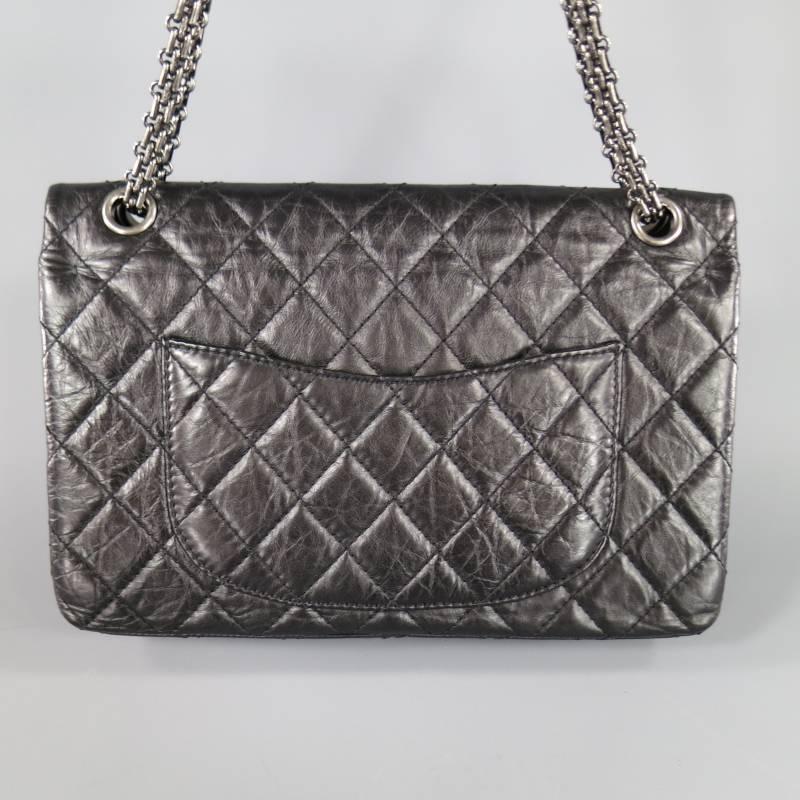 This gorgeous CHANEL 2.55 Reissue shoulder bag comes in a semi matte textured and quilted black leather and features a flap closure with the original twist lock closure, gunmetal grommets with chain shoulder strap, internal zip pocket under the
