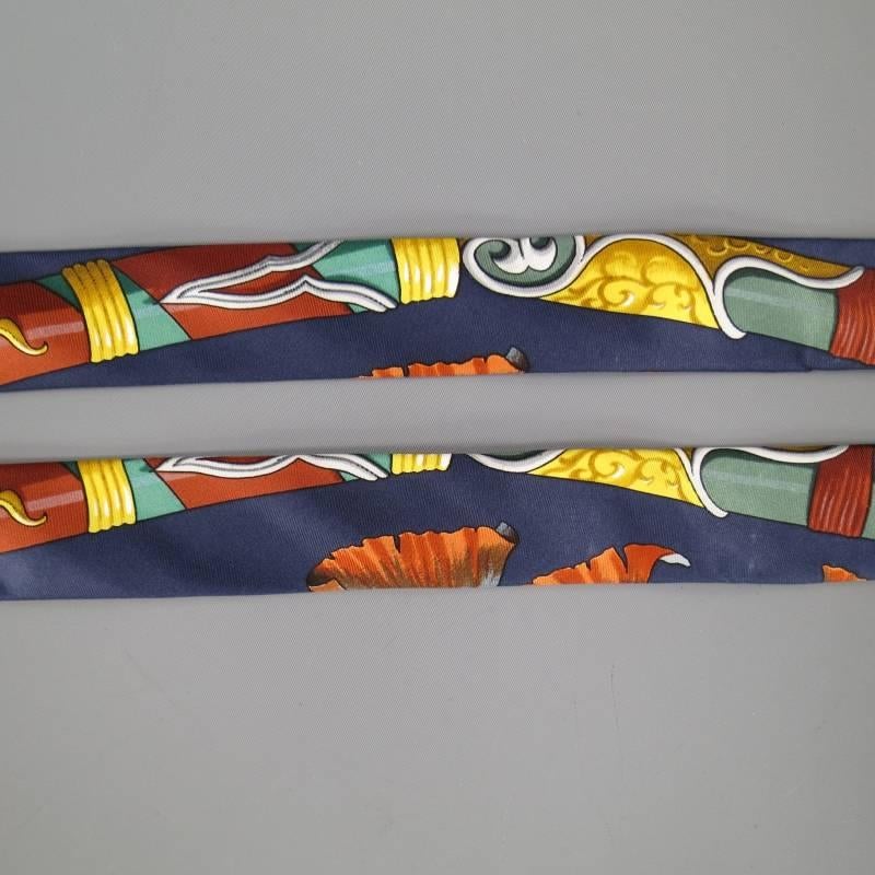 HERMES Suspenders consists of 100% silk material in a navy color toned. Designed with a novelty print throughout body of straps with gold color tone hardware/ clasp. Gold, Brick and Teal color tones. Leather back section with 
