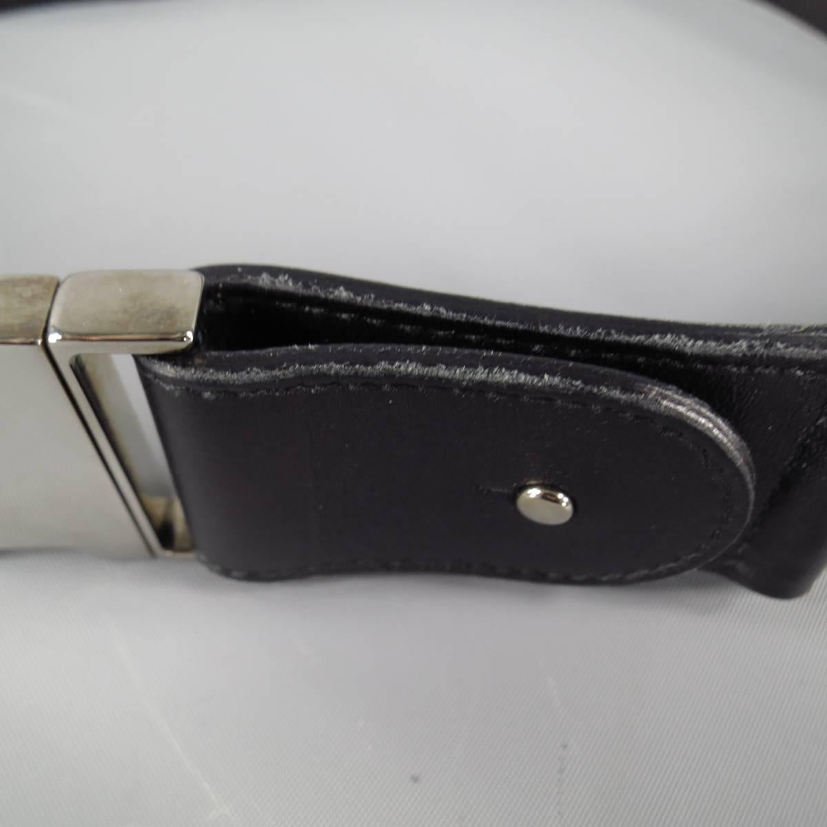 GUCCI elastic belt features utilitarian buckle design with leather accents and chrome shine hardware in Black, made in Italy.

Excellent Pre-Owned Condition    Marked: 34

Measurements: 

Length: 31 in. 
Width: 1.5 in.