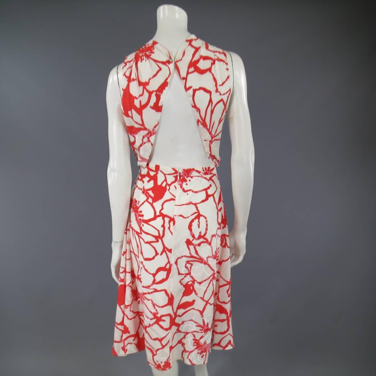 This fabulous NINNA RICCI dress comes in a white and red floral print silk and features a high neck, asymmetrical pleated drape front, a line skirt, belt, and open back with faux button closures. Made in France.
 
Excellent Pre-Owned