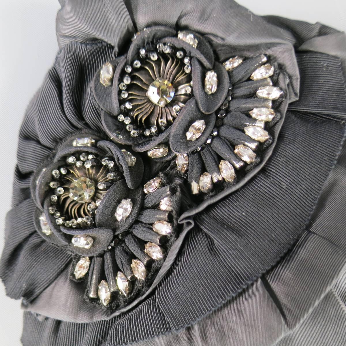 This lovely ELIE TAHARI clutch bag comes in black matte naylon with a gathered top zip closure, and ruffled ribbon and satin details with gorgeous rhinestone crystal flower embellishments.
 
Brand New Condition.
 
Measurements:
 
Length: 14
