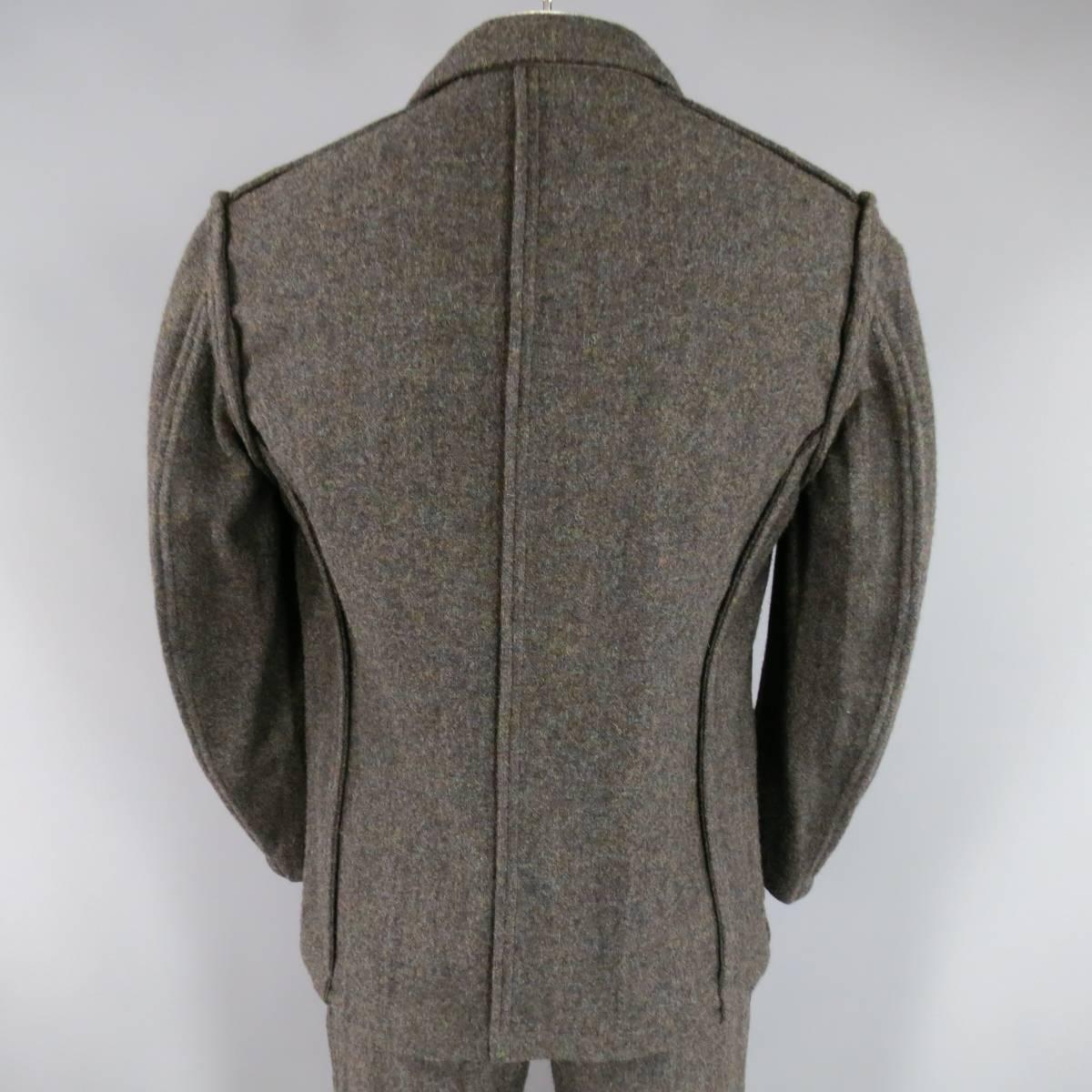 This rare COMME des GARCONS Fall 1998 suit comes in a very unique multi-color blended wool and includes a three button sport coat with a wide notch lapel, thick, reverse seam piping details, and patch pockets, with matching pleated, cuffed trousers.