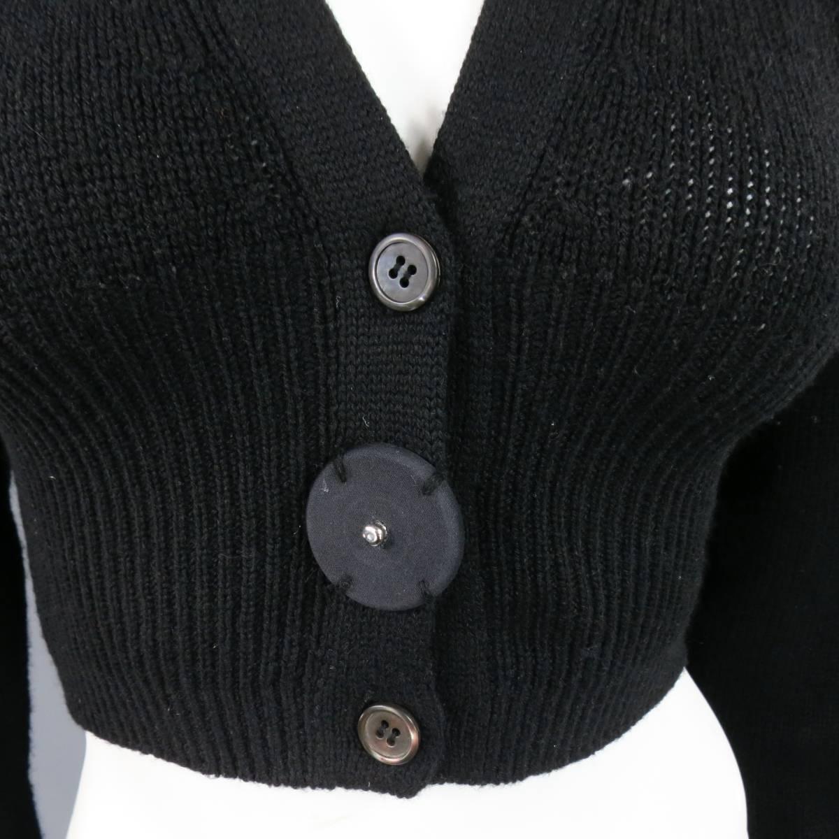 This cropped PRADA cardigan comes in a soft cashmere knit with a V neck, ribbed bands, and three button closure with oversized snap embellishment. Made in Italy.
 
Good Pre-Owned Condition.
Marked: 44
 
Measurements:
 
Shoulder: 17 in.
Bust: