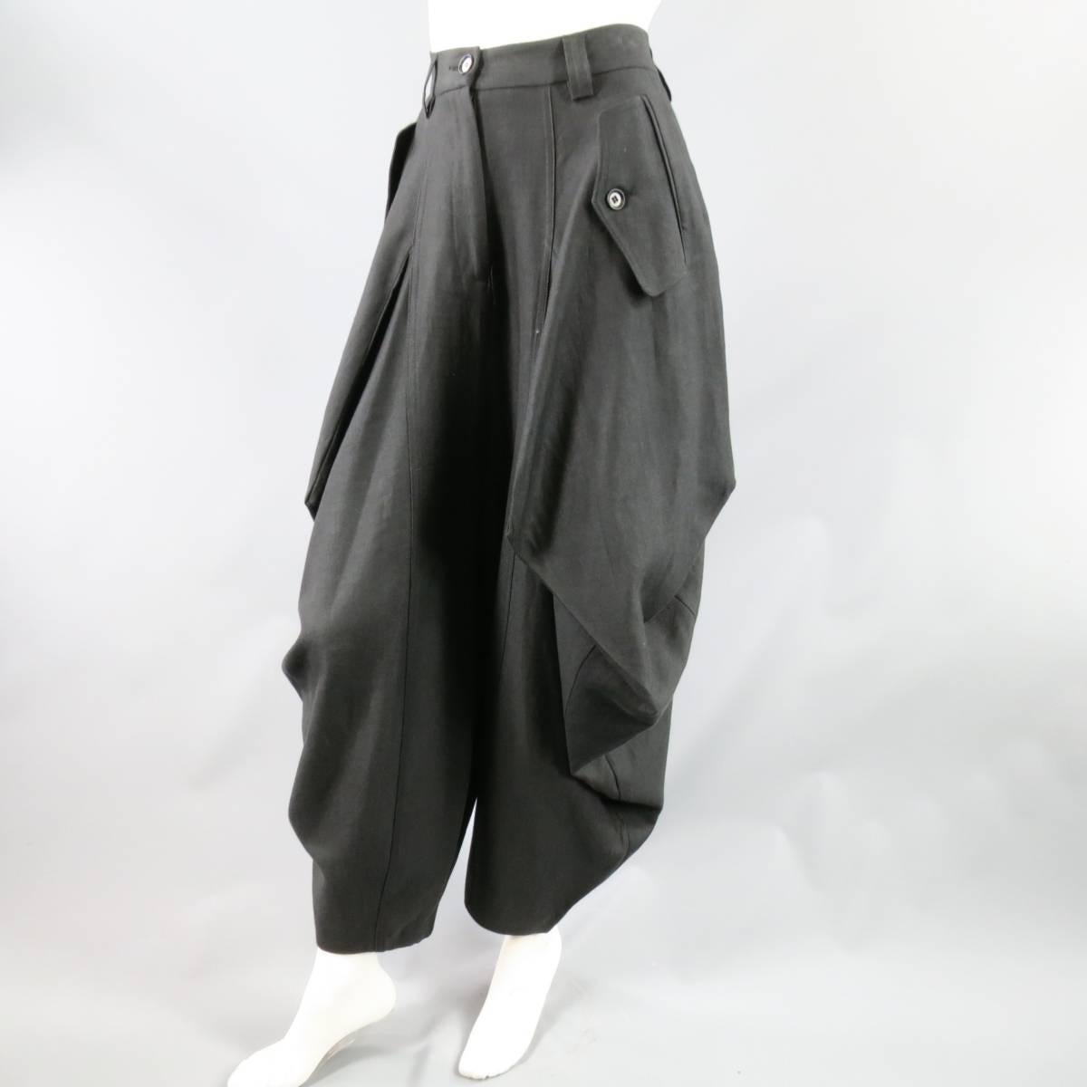 These ultra chic IVAN GRUNDAHL drop crotch trousers come in a charcoal wool twill with symmetrical, slanted, flap hip pockets and unique geometric seam Origami drape construction. Made in Portugal.
 
Excellent Pre-Owned Condition.
Marked: 36
