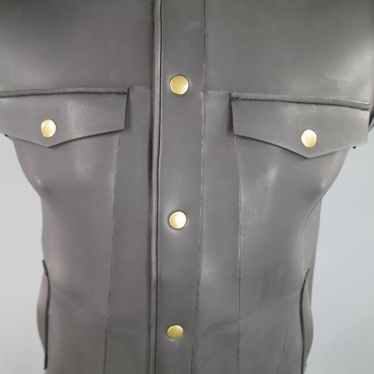 This rare ROBERT GELLER vest comes in charcoal grey neoprene and features a classic denim trucker jacket cut with gold tone snaps and pointed collar. Excellent Condition with imperfections on shoulder shown in detail shots. Made in Japan. Retails: