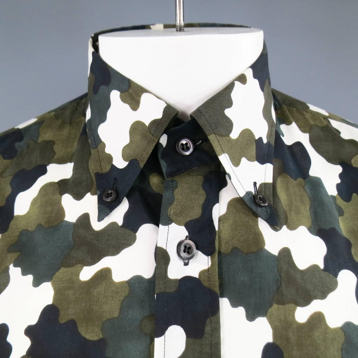 This fitted  PRADA dress shirt comes in graphic olive green, black, and white high contrast camouflage print with a pointed button down collar and double patch flap pockets. Made in Italy.
 
Excellent Pre-Owned Condition.
Marked: 41/16
