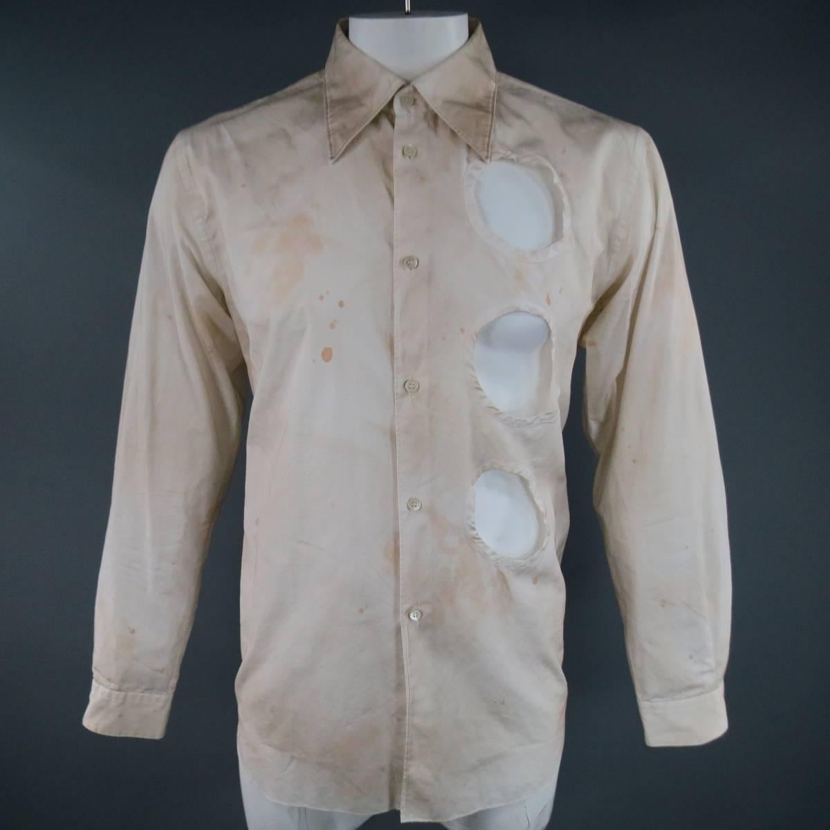 COMME des GARCONS Long Sleeve Shirt consists of cotton material in a beige color tone. Designed with a pointed collar, button-up front and cut-out hole detail on one side. Distressing can be seen throughout shirt. Single button cuffs. Made in