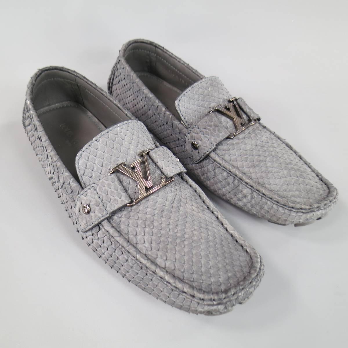 LOUIS VUITTON Loafers consists of snake-skin leather material in a dark grey color tone. Designed in a driver style, square-toe front, top edging trim with tone-on-tone stitching throughout body. Textured appearance with large silver 