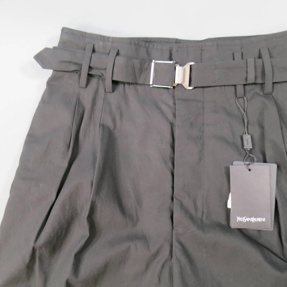 These rare YVES SAINT LAURENT dress pants come in a light weight cotton and feature a high rise, oval shaped taper leg, pleated flat font, and matching fabric belt with silver tone embossed closure. Unhemmed. Made in Italy.
 
Brand New with