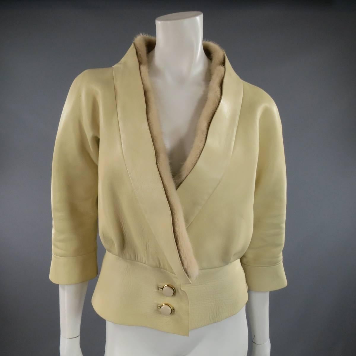 This lovely MARC JACOBS cropped jacket comes in tan beige smooth leather with three quarter sleeves, thick waist band with white button closure, tied leather belt, and tan mink fur collar. Marks throughout leather shown in detail shots. Made in