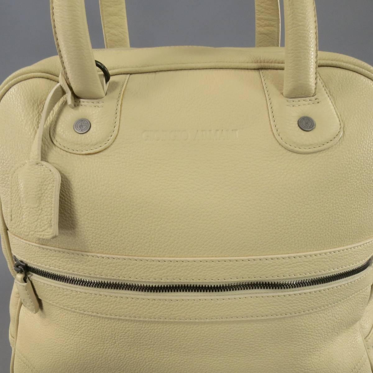 This large tote bag by GIORGIO ARMANI comes in pebbled cream beige leather and features a logo embossed front, zip pocket, double leather top handles with key clochette, and top zip closure with snap and lock option. Faint marks shown in detail