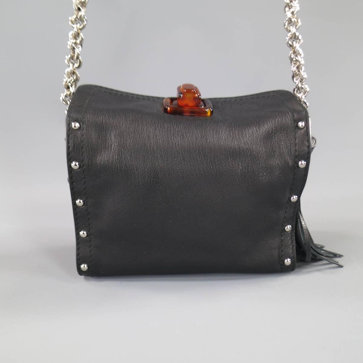 This gorgeous LANVIN crossbody bag comes in smooth black silver studded leather in a rectangular shape with a tortoise twist closure, side hoops with black leather tassels, and chain strap with studded leather shoulder piece. With Dust Bag. Made in