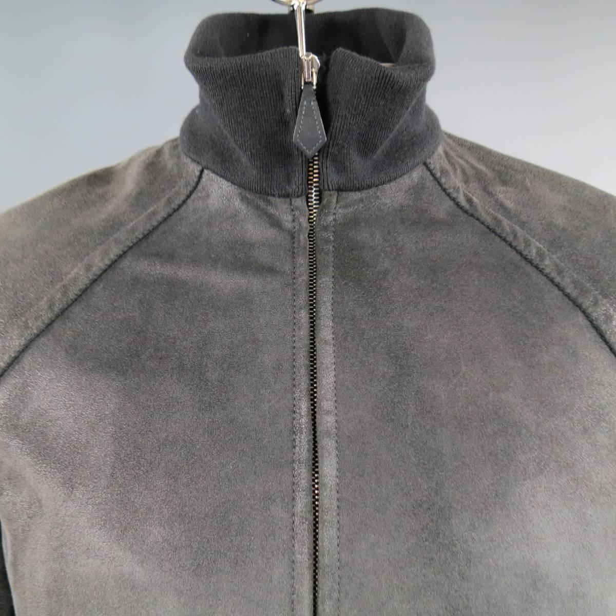 This Men's HERMES jacket comes in charcoal gray shiny distressed suede  and features a high ribbed knit neck, raglan sleeves, double zip pockets, and wool lining. Wear throughout suede. Made in France.
 
Good Pre-Owned Condition. Retails at