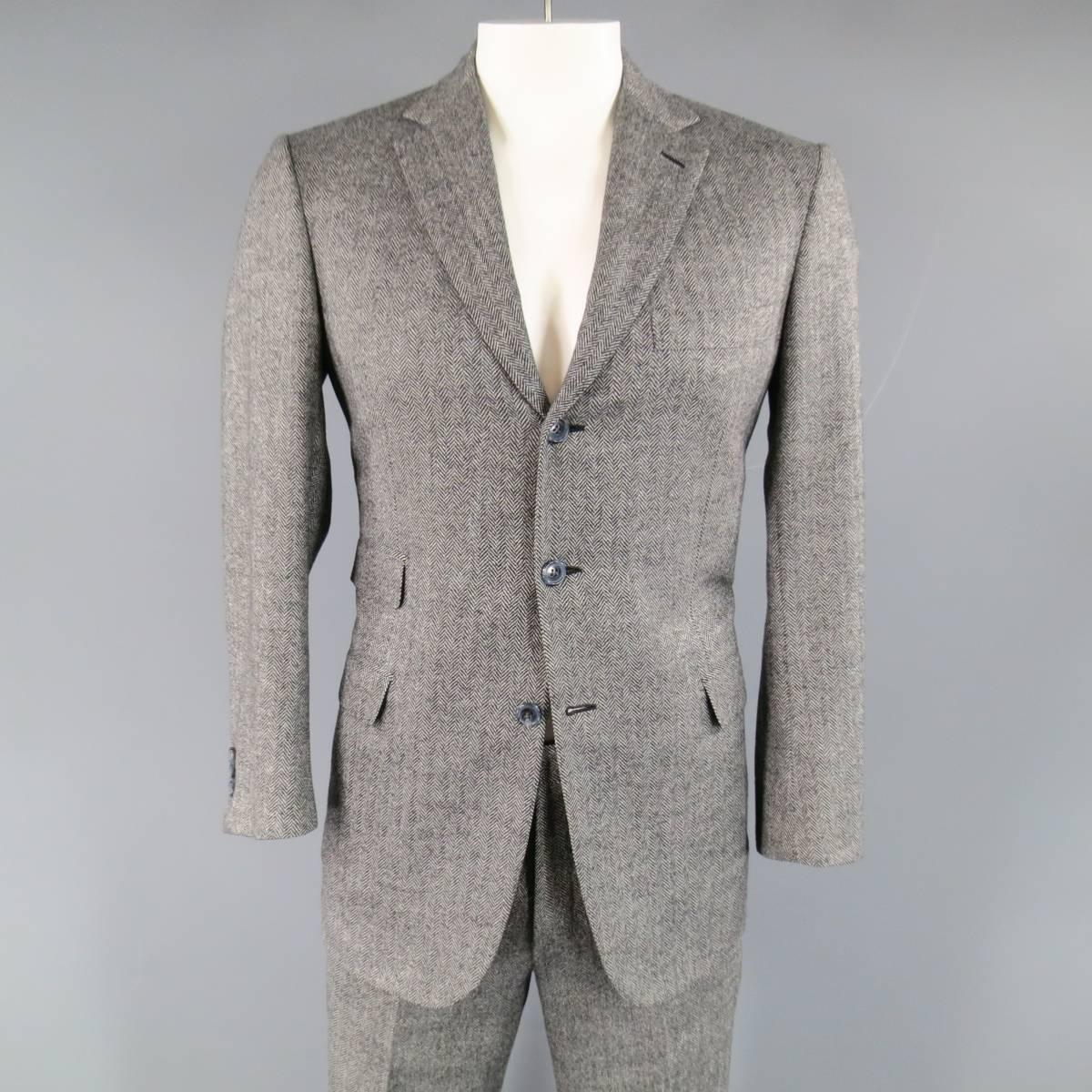 Men's BRIONI for WILKES BASHFORD two piece suit in black and white Herringbone wool includes a notch lapel sport coat with triple flap pocket front, three button closure, double vented back and matching flat front, cuffed dress pants. Made in