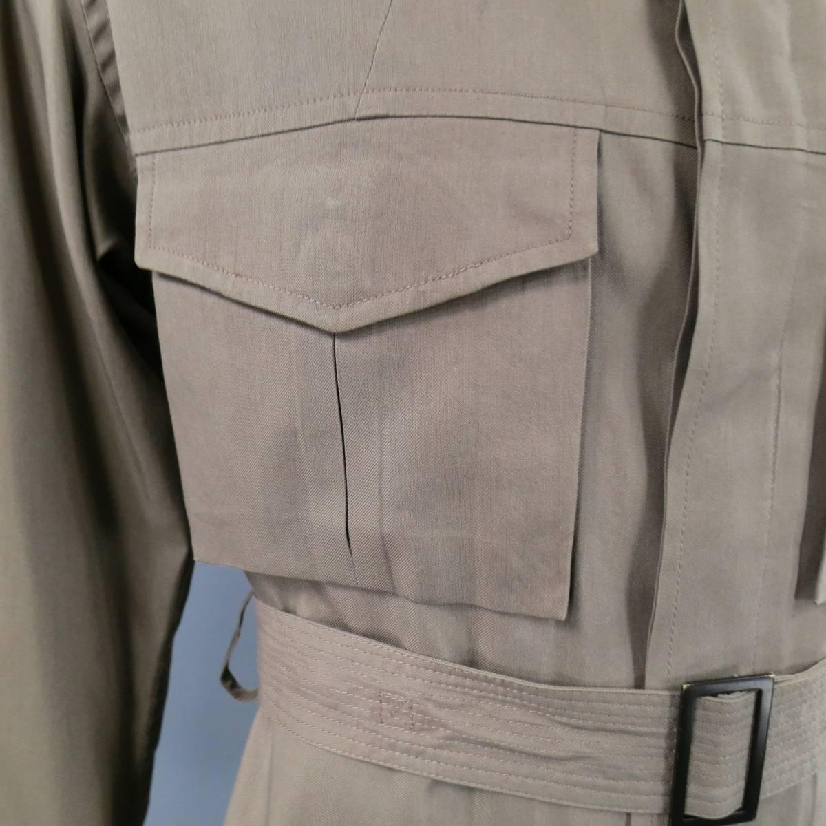 Chic YVES SAINT LAURENT men's safari jacket in taupe cotton / silk twill featuring a pointed collar, shoulder epaulets, hidden button down closure with placket, patch flap pockets with covered buttons, and belted waist. small chest stain shown in
