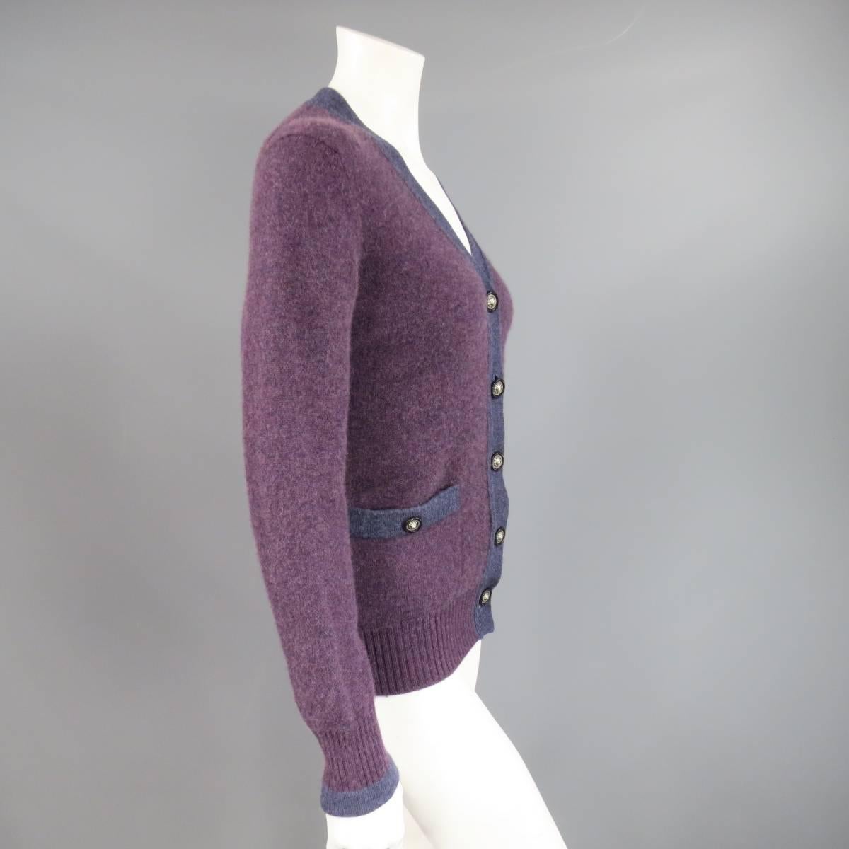 This classic CHANEL cardigan comes in a two tone plum purple cashmere with a deep V neck, double patch pockets, and silver tone lion head buttons. Made in The UK.
 
Good Pre-Owned Condition.
Marked: 42
 
Measurements:
 
Shoulder: 16.5