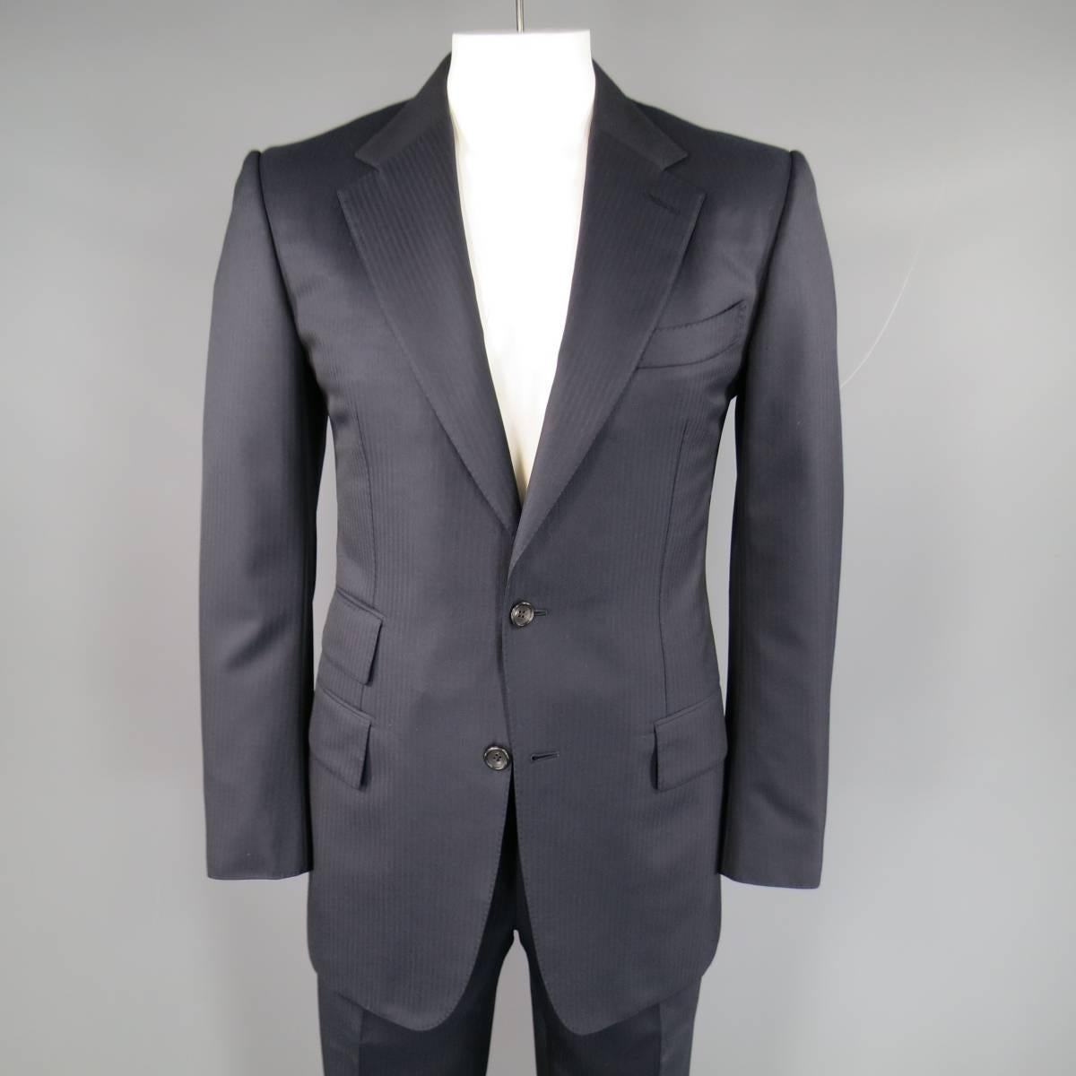 Classic TOM FORD suit in deep Midnight Navy blue striped wool twill includes a two button 40 long sport coat with triple flap pockets, notch lapel, functional button cuffs, and double vented back and flat front trousers with cuffed hem and signature
