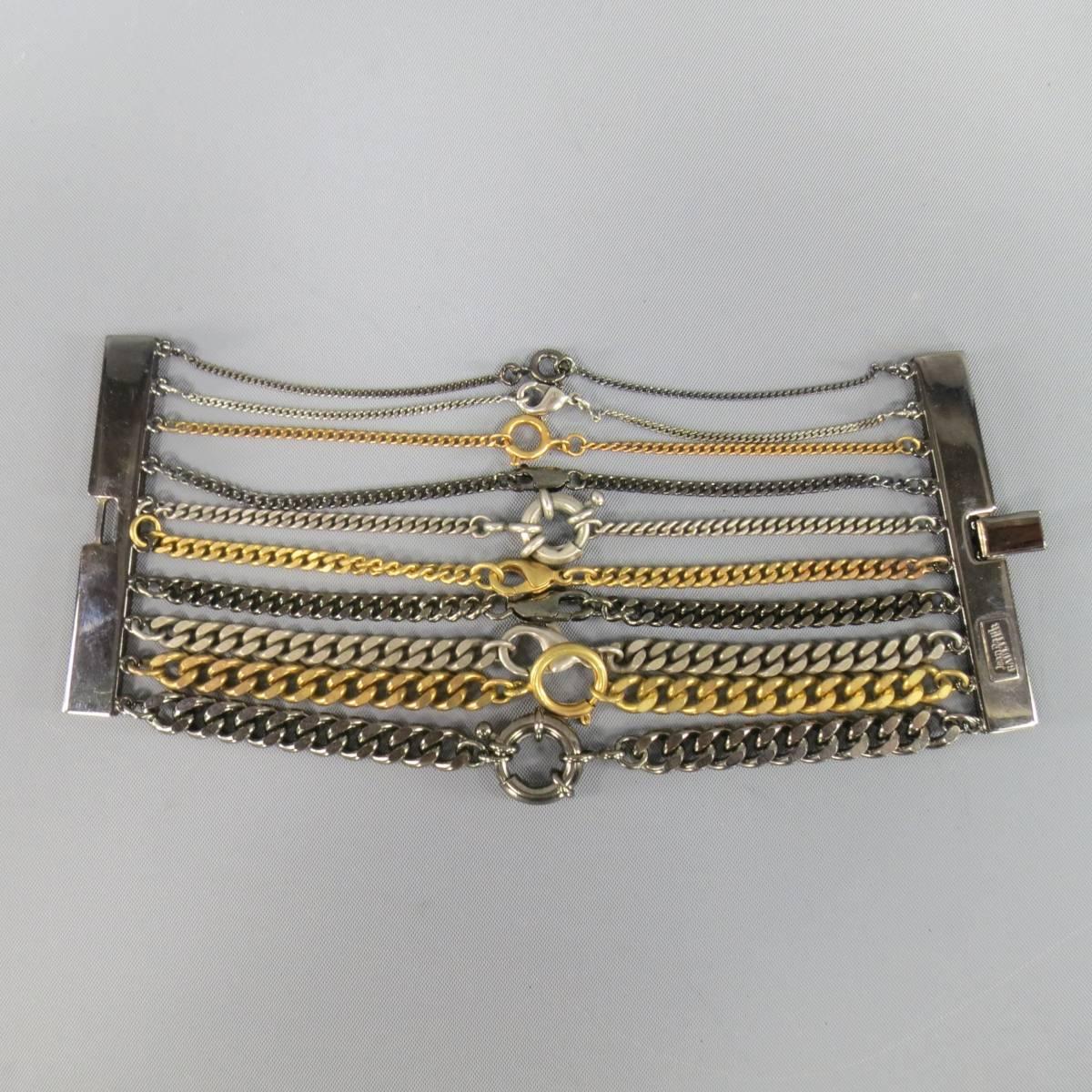 Fabulous vintage JEAN PAUL GAULTIER cuff bracelet features gunmetal brass bars with various sized silver and gold clasped chains.Made in Italy.
 
New with Tags.
 
Length: 6.5 in.
Width: 2.75 in.