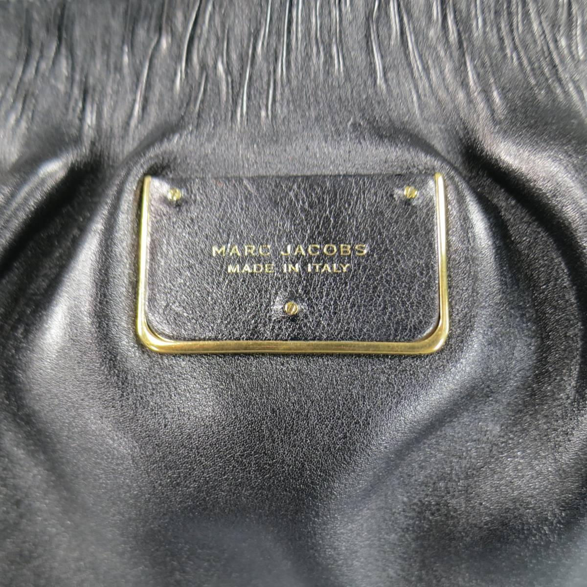 Lovely MARC JACOBS shoulder bag in black gathered leather featuring a gold tone double zip closure, pleated top, textured base, front plaque, and double woven chain top handles. Hardware protector stickers still attached. Made in Italy.
 
New