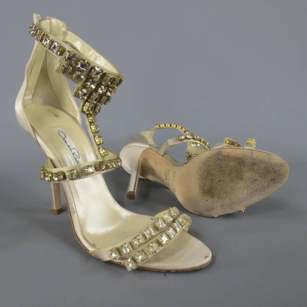 Stunning OSCAR DE LA RENTA evening sandals in champagne silver silk satin and feature a double toe strap with tulle covered crystal rhinestones, covered heel, and jeweled ankle T strap. Marks on inner side. Made in Italy.
 
Excellent Pre-Owned