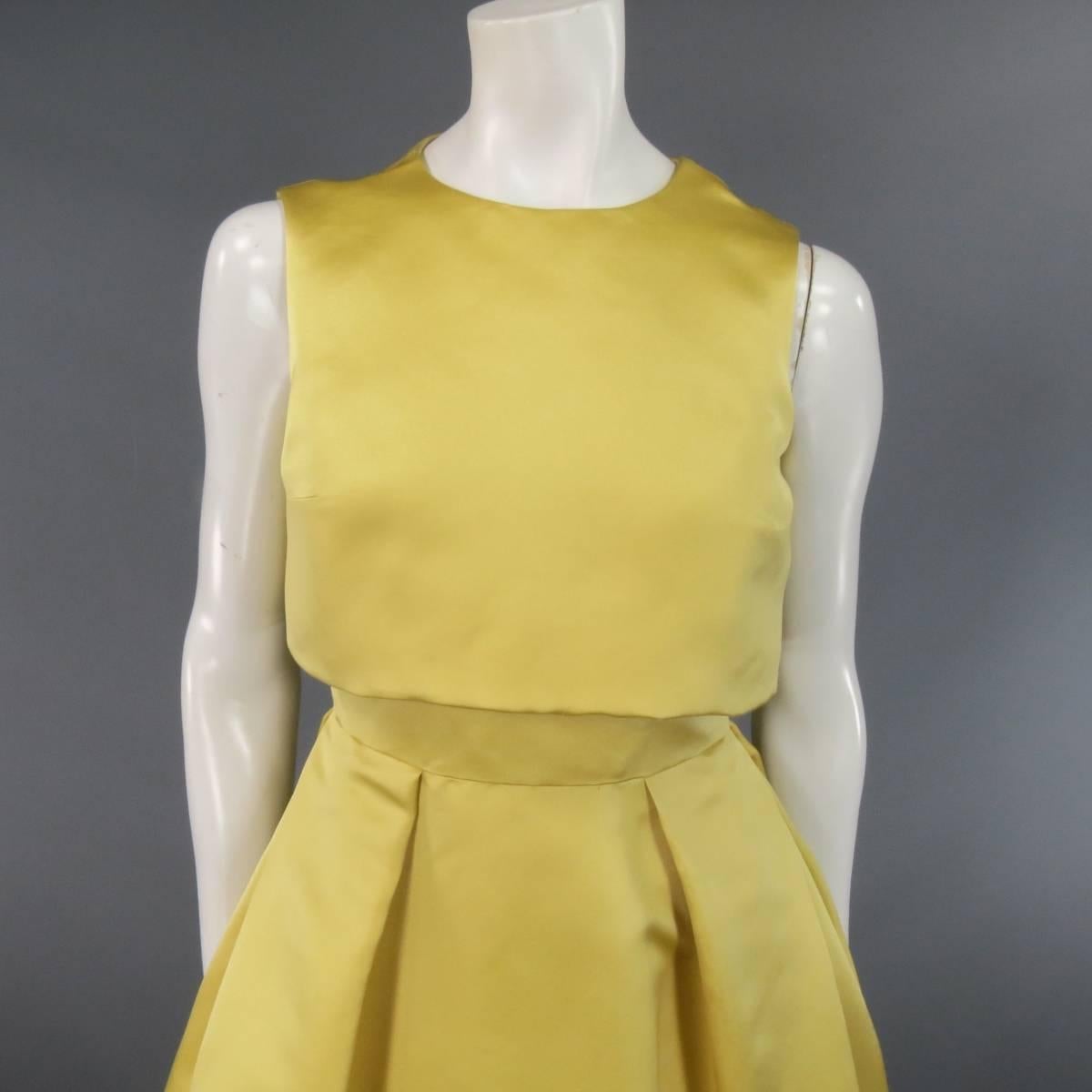 This gorgeous CHRISTIAN DIOR sleeveless cocktail dress comes in a light gold yellow silk satin and features a high round crew neckline, cropped bib overlay, fitted waist, and box pleated flare skirt. Made in Italy.
 
Excellent Pre-Owned