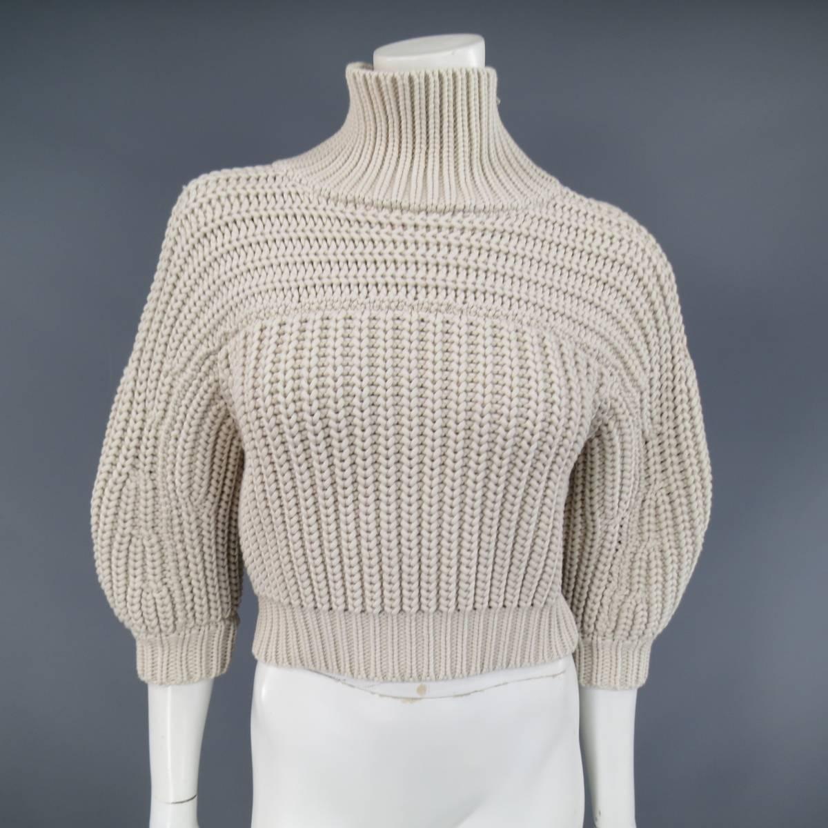 This lovely BURNELLO CUCINELLI sweater comes in a a khaki beige cotton blend chunky interlock knit and features 3/4 puff sleeves, and a zip shoulder mock neck with silver tone sparkle chain detail. Made in Italy.
 
Excellent Pre-Owned