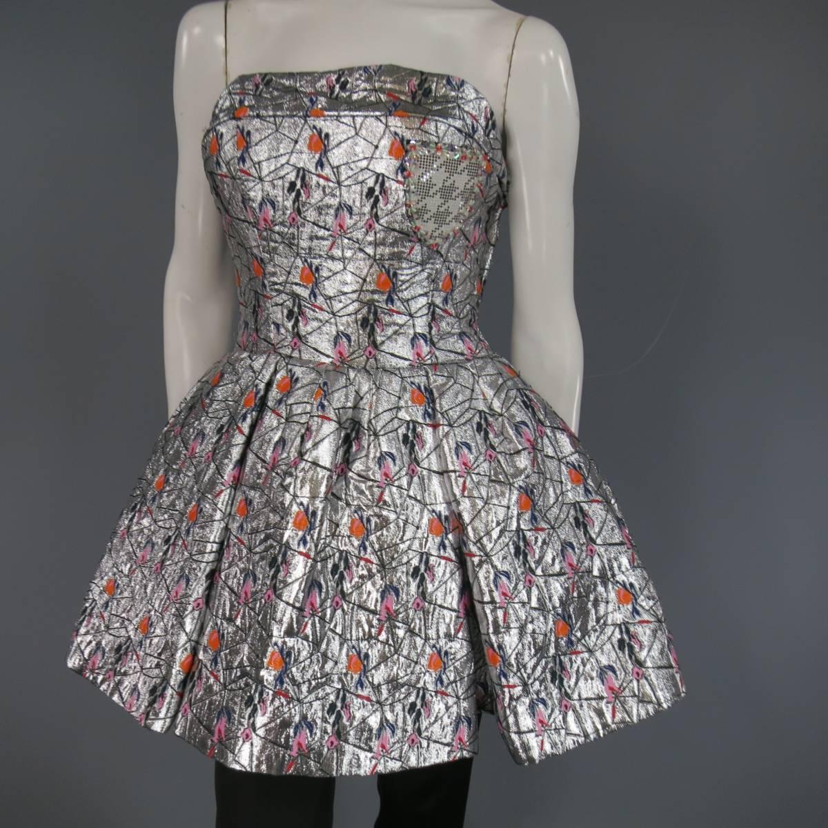 This fabulous CHRISTIAN DIOR Spring 2014 Collection strapless cocktail mini dress look comes in a structured metallic silver jacquard fabric with orange, red, & pink floral embroidery and features a built in bustier bodice with cuffed hem, box