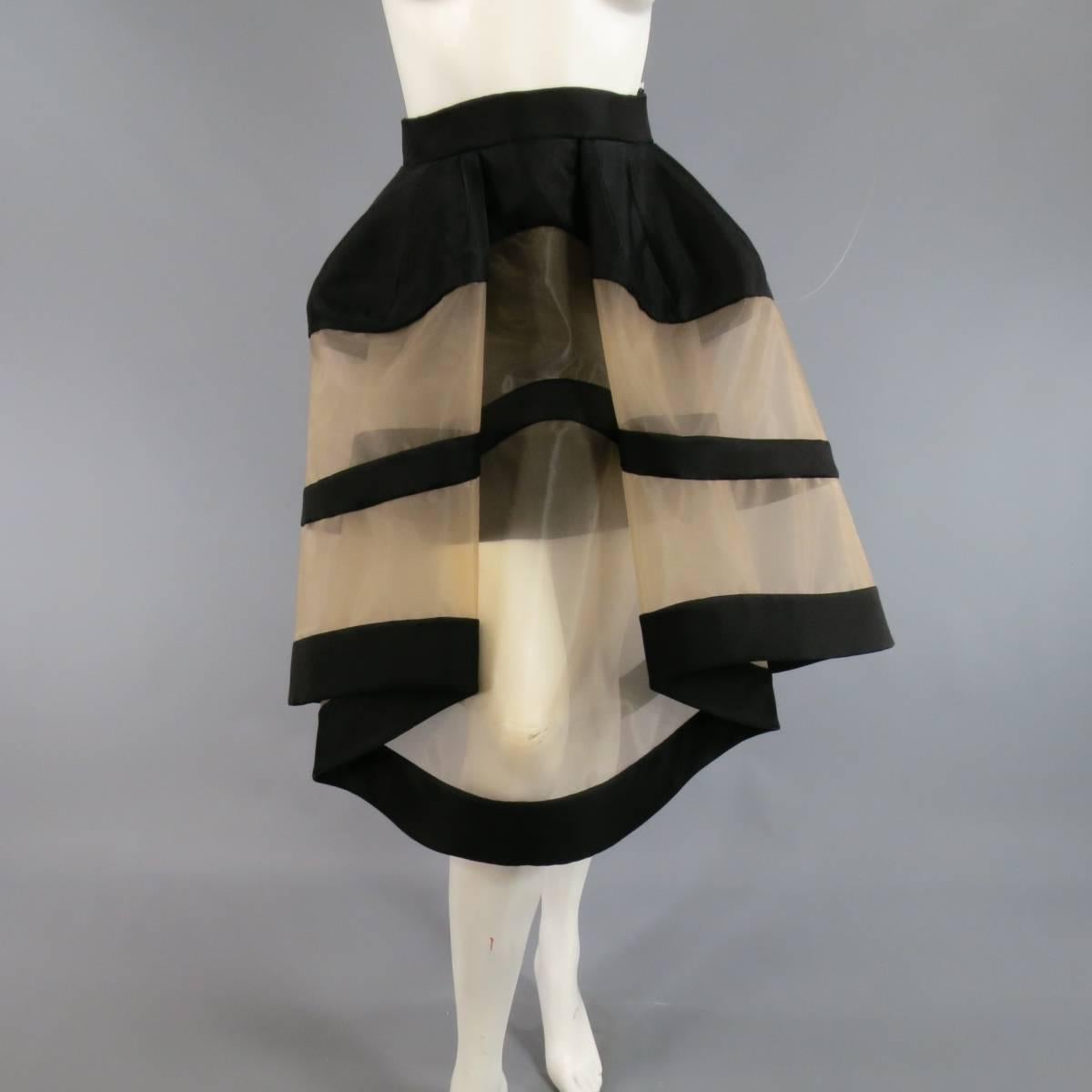 This fabulous DELPOZO cocktail skirt comes in structured black fabric with tan mesh panels and features an exaggerated, symmetrical construction for an extreme dramatic silhouette with graphic color block lines. Made in Spain.
Retails at