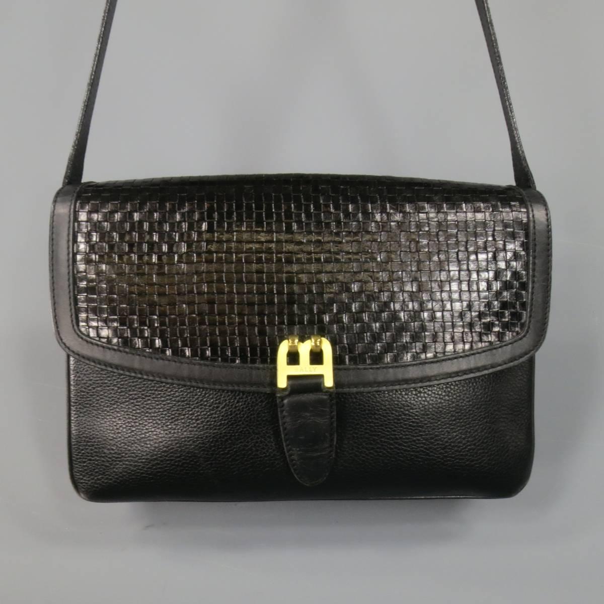 This rare vintage BALLY handbag comes in black pebbled leather and features a woven leather flap with gold tone B 