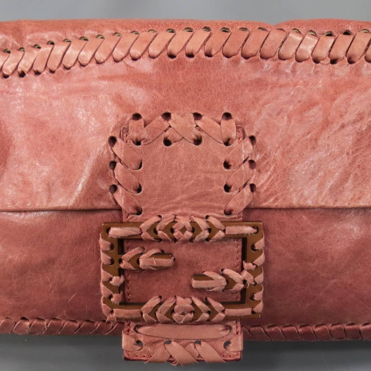 This gorgeous FENDI shoulder bag comes in a distressed dark pink leather and features whipstitch details throughout, rectangular shape, flap snap closure with oversized whipstitch wooden logo, adjustable shoulder strap that can be removed to wear as