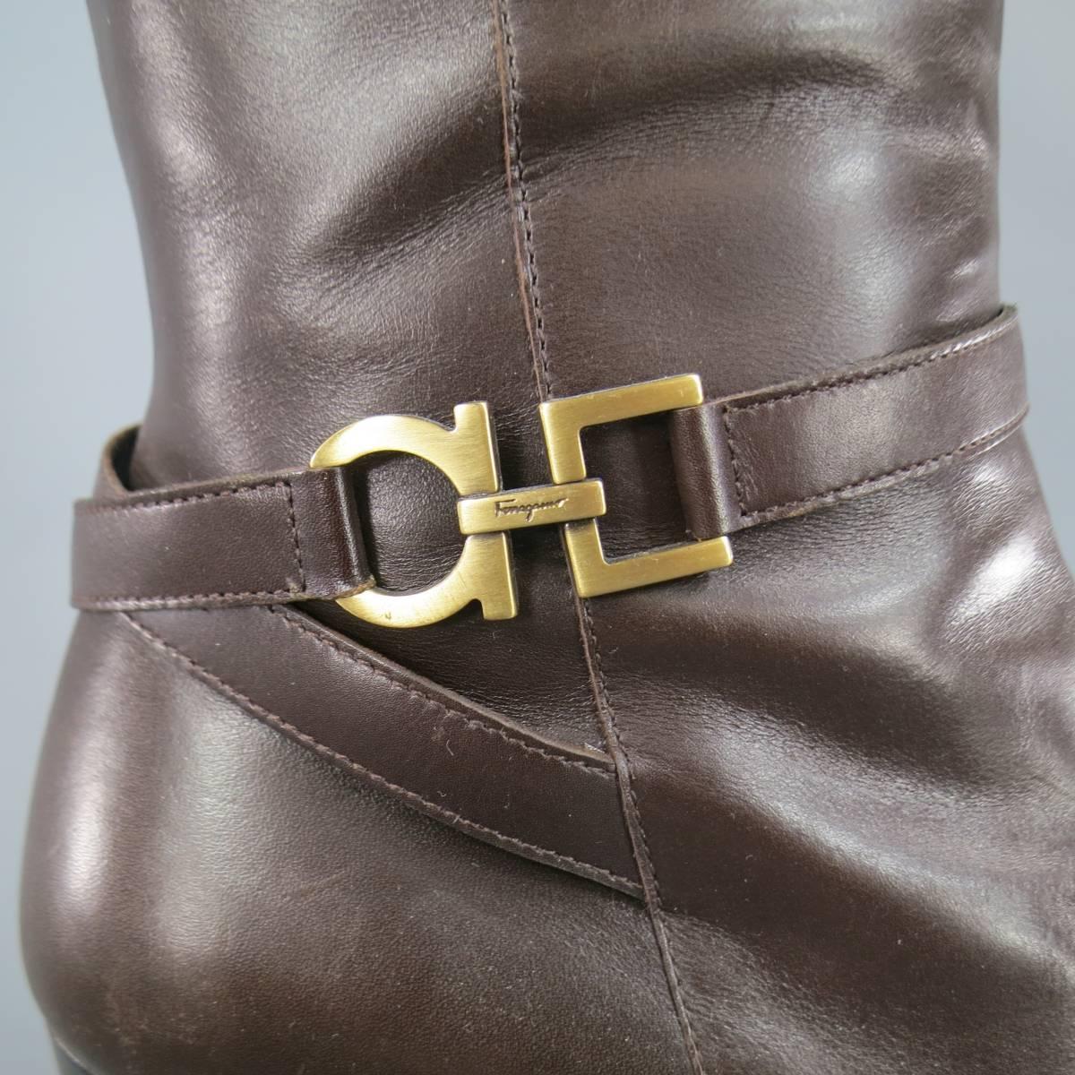Classic SALVATORE FERRAGAMMO calf boots in brown leather calf high boots featuring a cross ankle strap with gold tone Gancio hardware, low stacked heel, and internal zip. Made in Italy.
 
Excellent Pre-Owned Condition.
Marked: 7 1/2 B
 
Heel: