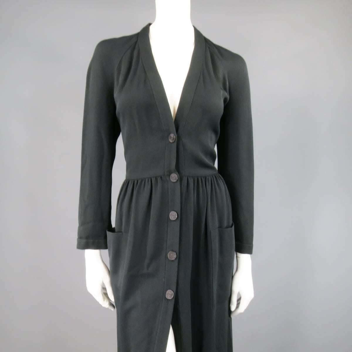 This fabulous vintage CHLOE dress comes in a black textured material and features a deep V neck, button up front with engraved buttons, raglan sleeves, gathered waist A line ankle length skirt, and double patch pockets. Evenly faded a couple shades