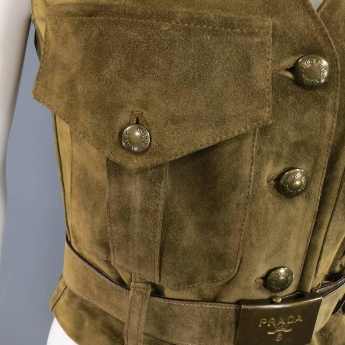 This gorgeous cropped PRADA vest comes in a an olive toned tan suede and features a deep V neckline, oversized military style patch flap pockets, dark gold tone engraved buttons, and matching logo slide buckle belt. Made in Italy.
 
Good Pre-Owned