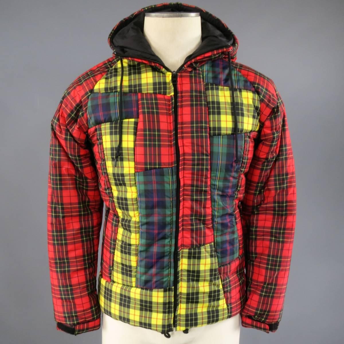 This rare COMME DES GARCONS winter puff jacket comes in red, green, & yellow tartan plaid nylon and features a drawstring hood, black zip front, double zip pockets, red raglan sleeves, velcro cuffs, and avant garde color block patchwork front.
