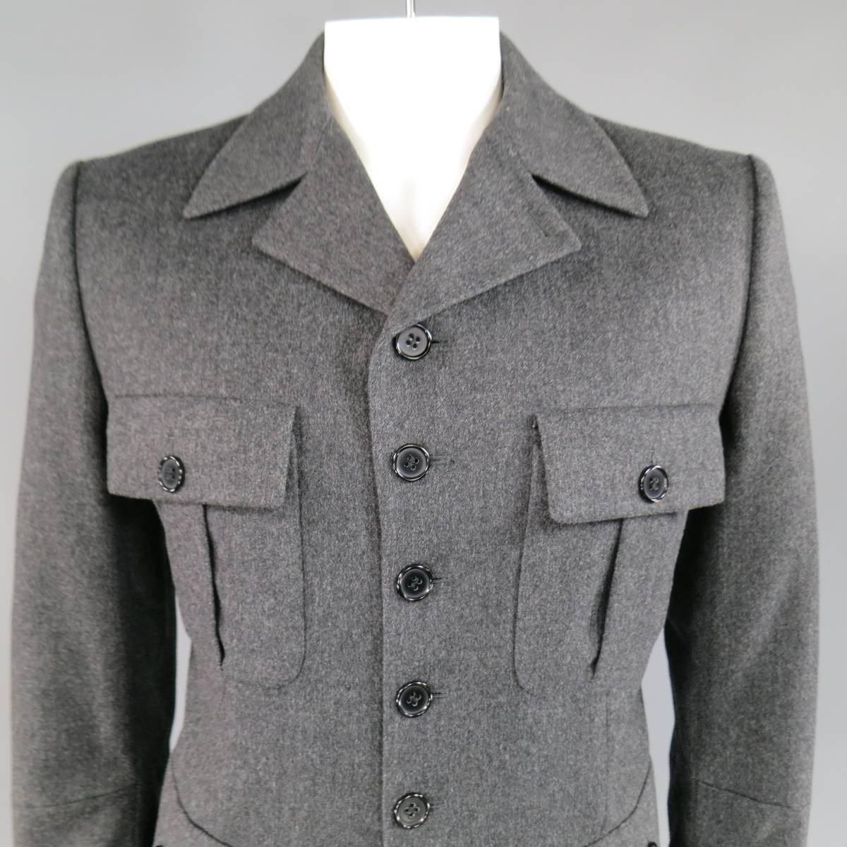 This ultra chic ALEXANDER MCQUEEN miltary style coat comes in a charcoal Heather gray wool blend fabric and features a five button closure, pointed collar lapel, and pleated patch flap pockets.  Made in Italy.
 
Excellent Pre-Owned