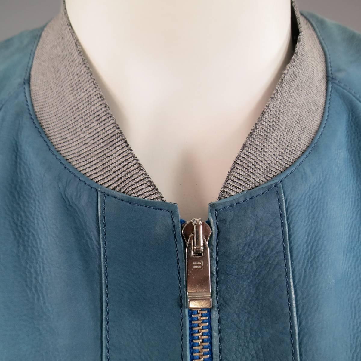 This rare BALENCIAGA bomber jacket comes in a soft teal blue matte leather with a nubuck feel and features a blue zipper front with silver tone hardware, Heather gray stretch cuffs, waistband, and collar, and double front pockets. Wear throughout
