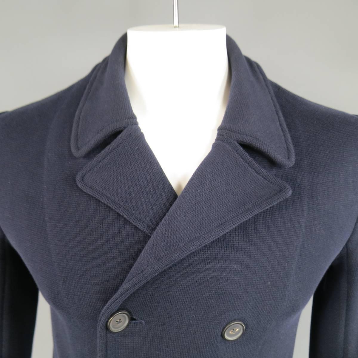 This classic men's JIL SANDER casual peacoat style jacket comes in a navy blue cotton knit, and features a double breasted button up closure, classic pointed collar lapel, and double slit pockets. Minor fading throughout knit. Made in Italy.
